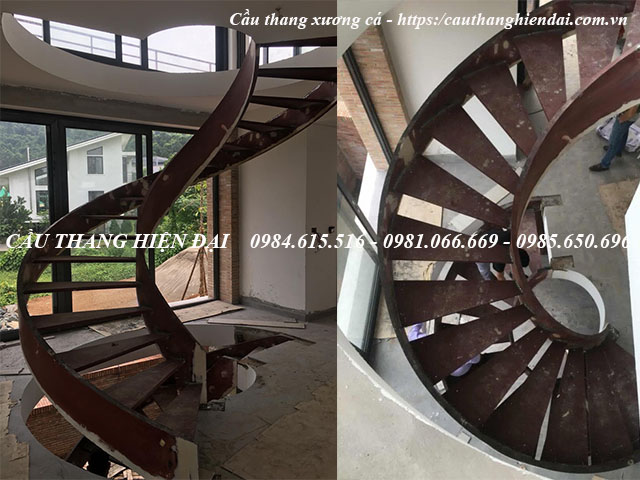 Mẫu cầu thang xương cá xoắn hiện đại và đẹp nhất, kính cong nghệ thuật, tay vịn gỗ lim nam phi