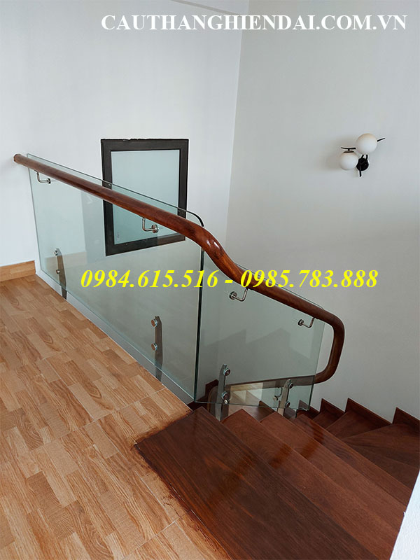 Mẫu cầu thang kính chân lửng tay vịn gỗ, báo giá cầu thang kính cường lực tay vịn gỗ lim nam phi giá rẻ nhất tại các quận ba đình, hai bà trưng