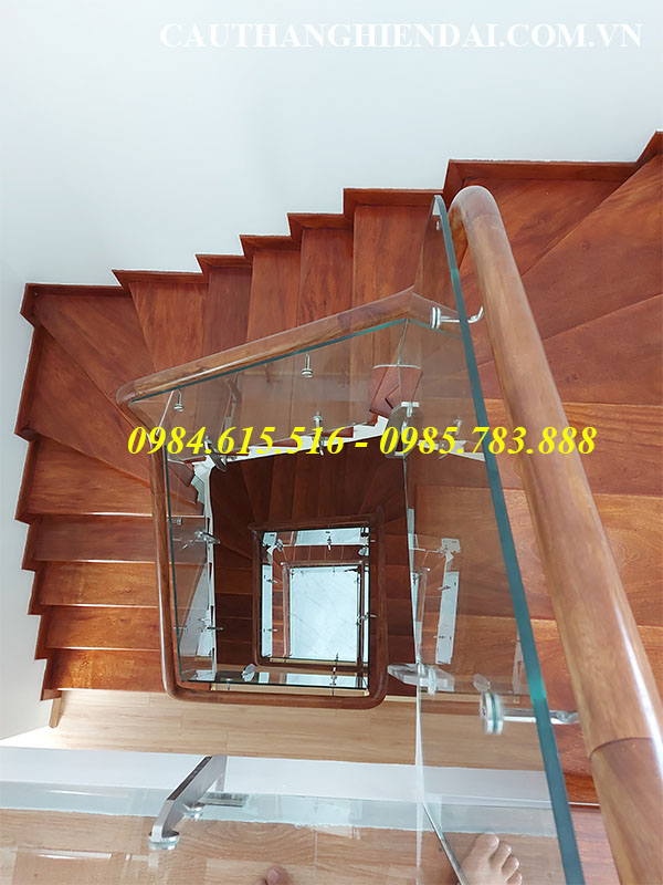 Mẫu cầu thang kính chân lửng tay vịn gỗ, báo giá cầu thang kính cường lực tay vịn gỗ lim nam phi giá rẻ nhất tại các quận bắc từ liêm, tây hồ
